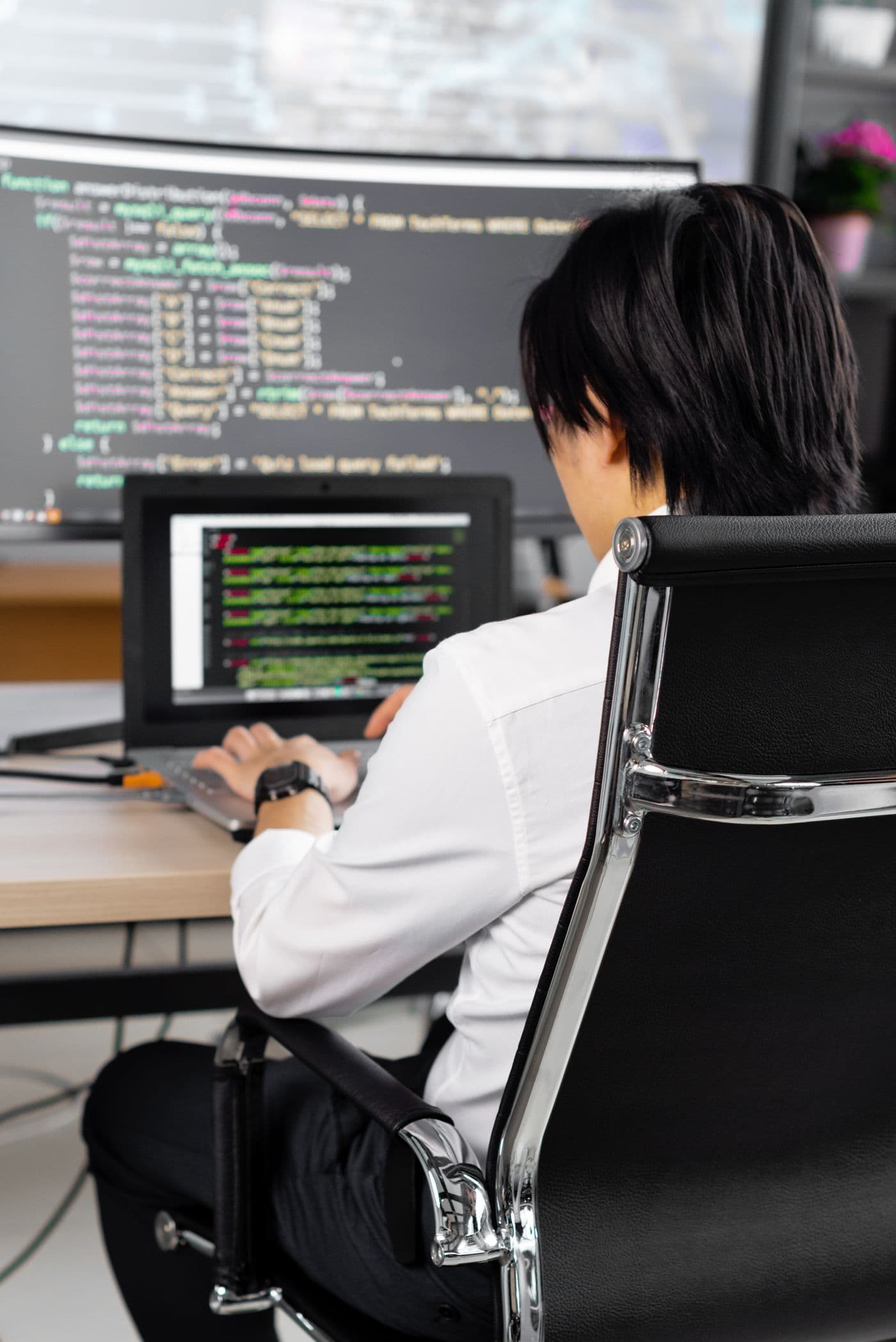 Developer working through a bespoke software build on a large monitor